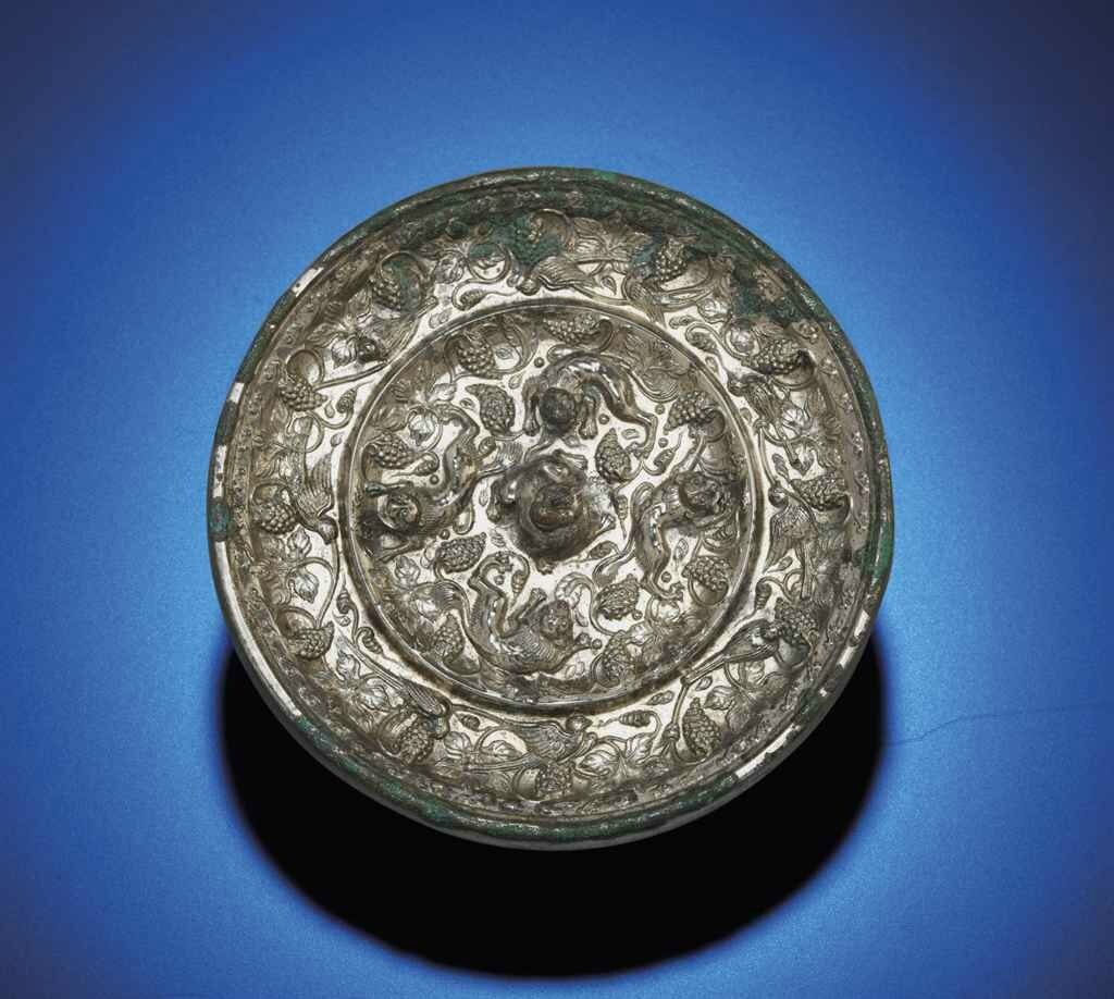A rare silvered bronze 'Lion and Grape' mirror, Tang dynasty (618-907) 