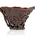 A fine carved brown rhinoceros horn wine cup with bamboo and peach blossoms symbolizing long life, china, 18th ct