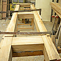 fabrication de colombage en assemblage de poutres en bois, verticales, horizontales où les vides sont hourdés.