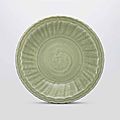 A large carved and moulded longquan celadon barbed-rim dish, early ming dynasty, 15th century