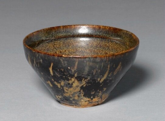 A small tortoise-glazed Jizhou bowl with prunus decoration at the inside